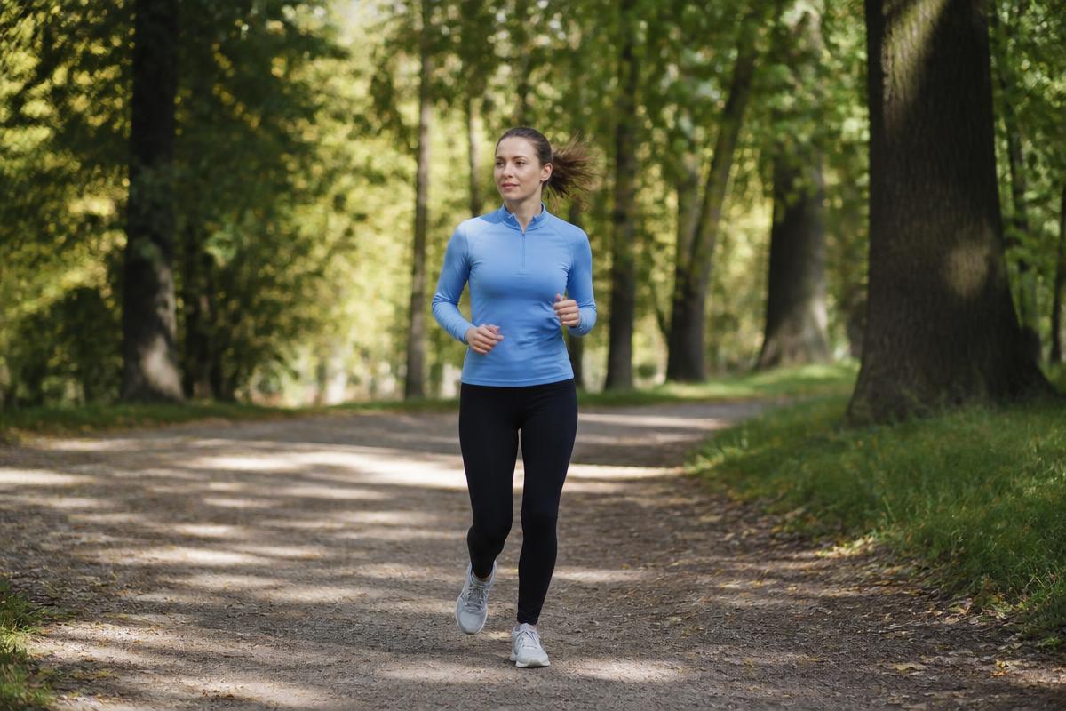 Runner jogging at a relaxed, comfortable pace along a leafy park path