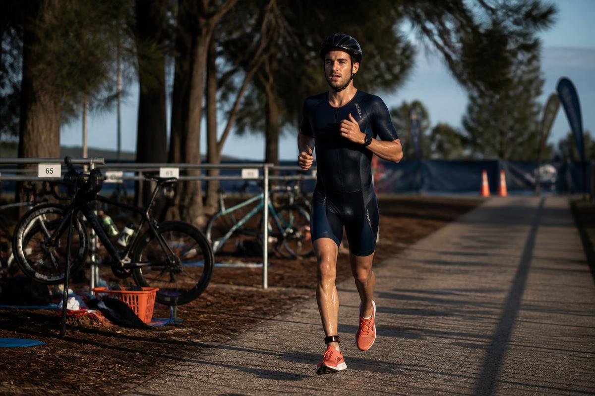 A triathlete running away from their racked bike in transition during a brick session